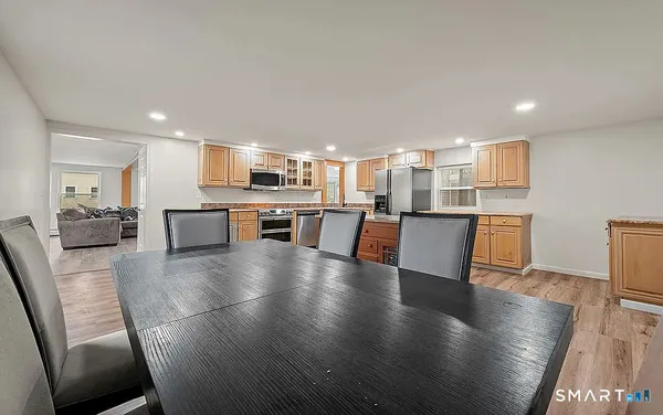 a view of a kitchen with kitchen island wooden floors and stainless steel appliances