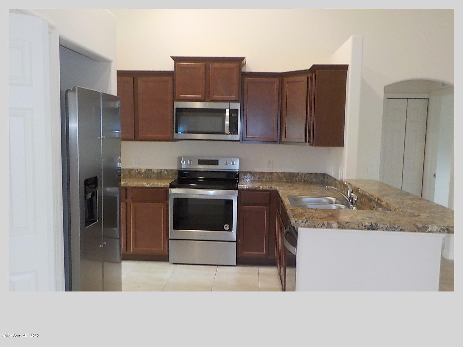 6795 Haddington Road Cocoa, FL 32927 - Photo 2 of 18 a kitchen with stainless steel appliances granite countertop a stove a refrigerator and a sink