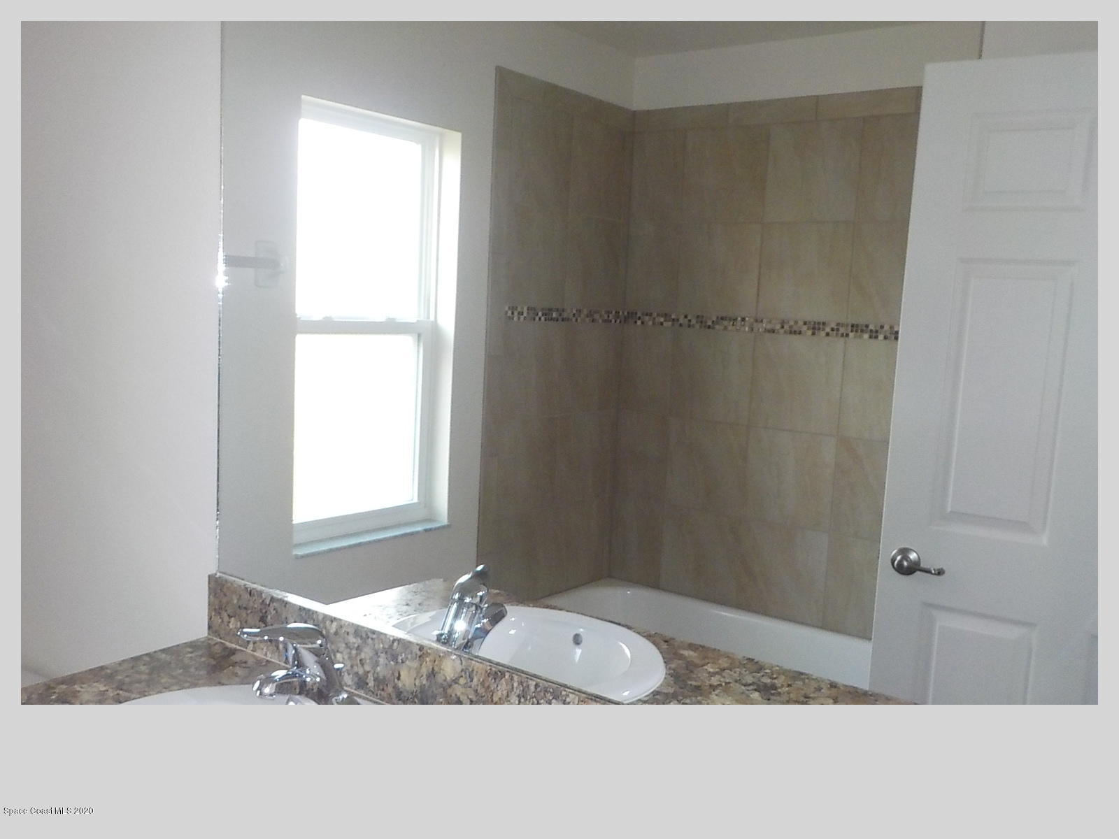 6795 Haddington Road Cocoa, FL 32927 - Photo 12 of 18 a bathroom with a tub sink and window