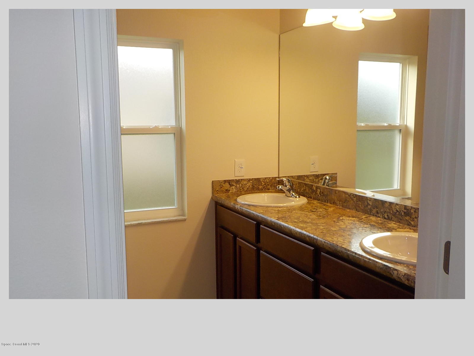 6795 Haddington Road Cocoa, FL 32927 - Photo 14 of 18 a bathroom with a granite countertop sink and a mirror