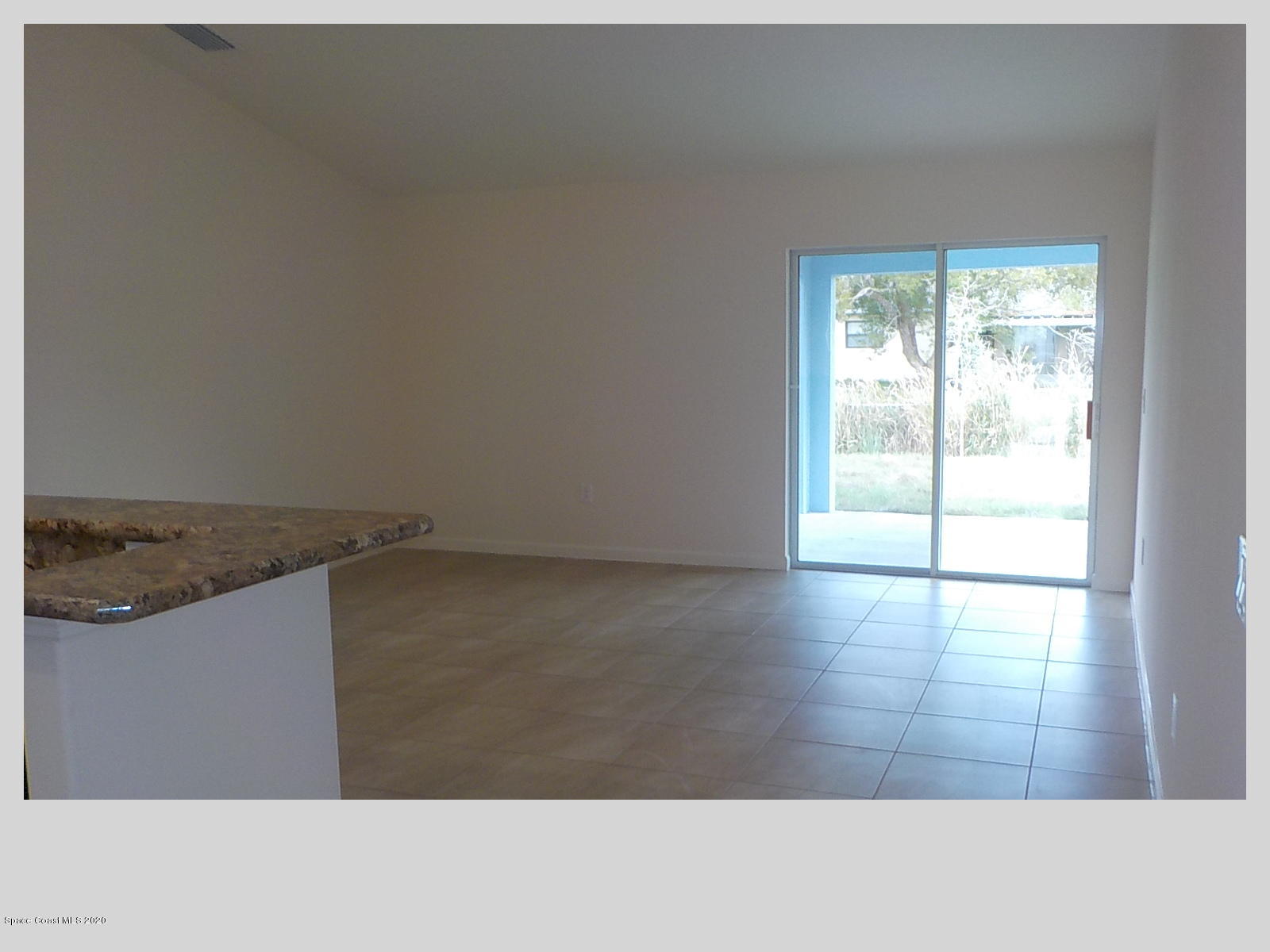 6795 Haddington Road Cocoa, FL 32927 - Photo 5 of 18 an empty room with wooden floor and windows