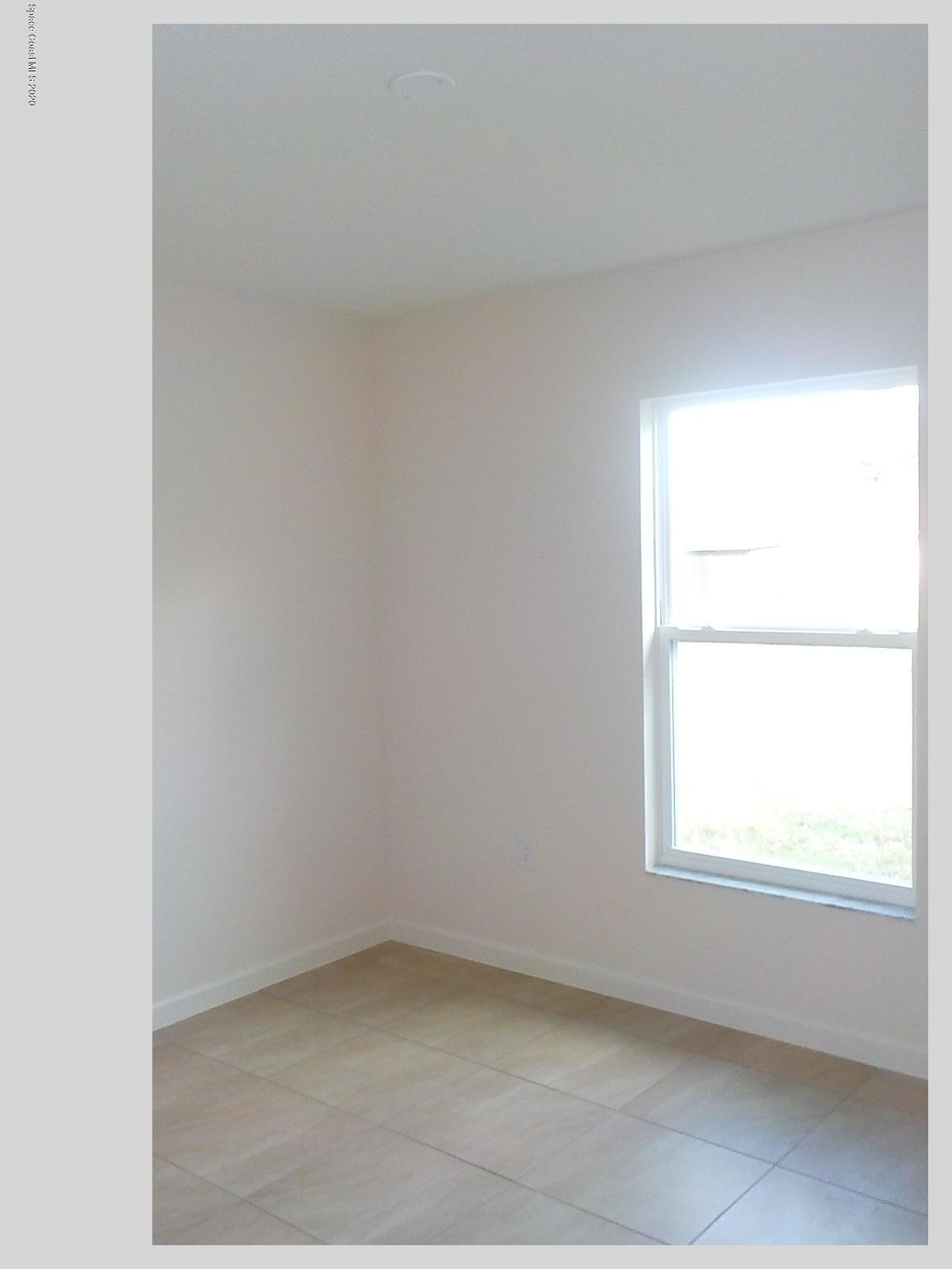 6795 Haddington Road Cocoa, FL 32927 - Photo 7 of 18 a view of an empty room with a window