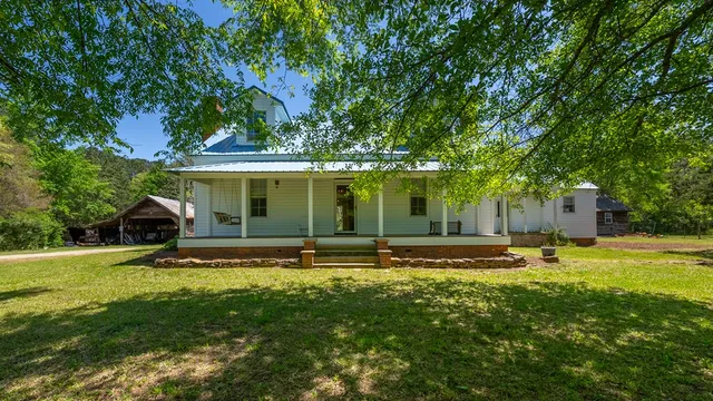 a view of a house with a yard and sitting area