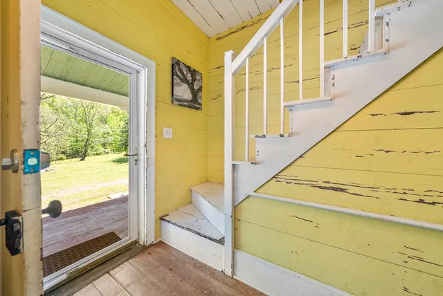 a view of a balcony with wooden floor and furniture