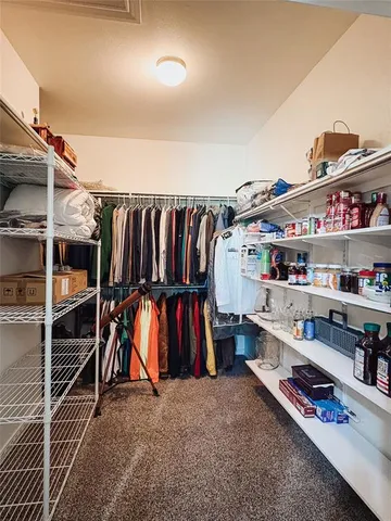 a view of walk in closet with clothes and shoes