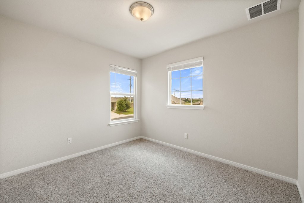 102 Ashford Way Georgetown, TX 78626 - Photo 21 of 28 A well-lit bedroom offering neighborhood views through dual windows.