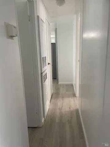 a view of a hallway with wooden floor
