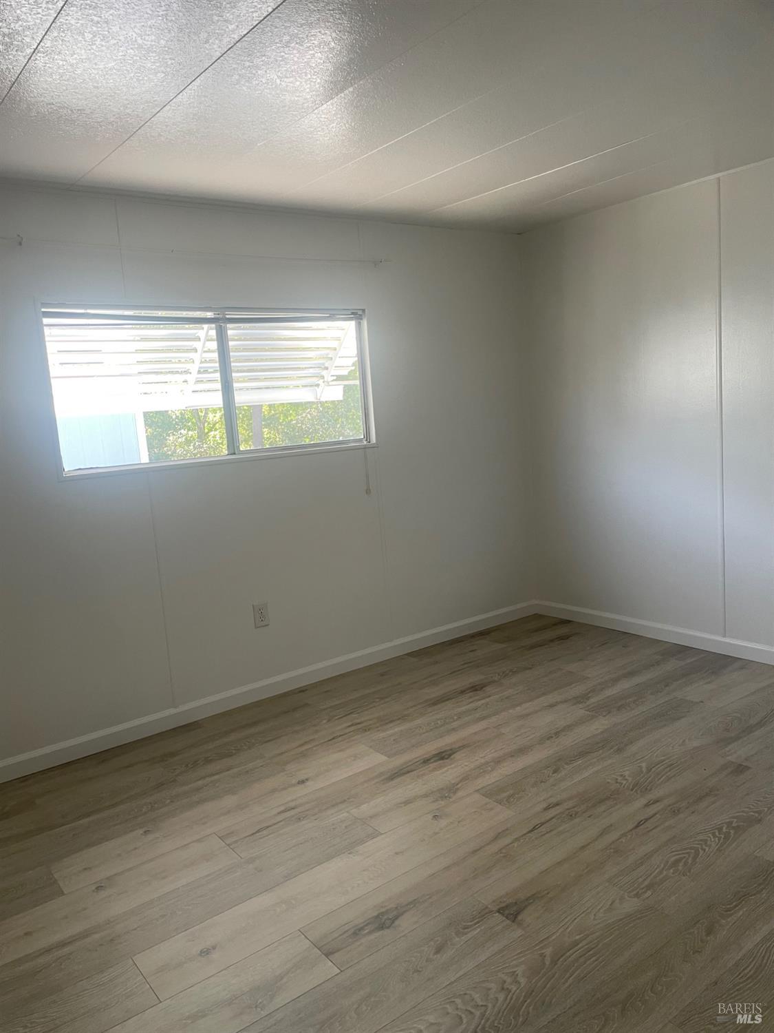 94 Buckwood Place Santa Rosa, CA 95409 - Photo 19 of 25 an empty room with wooden floor and windows