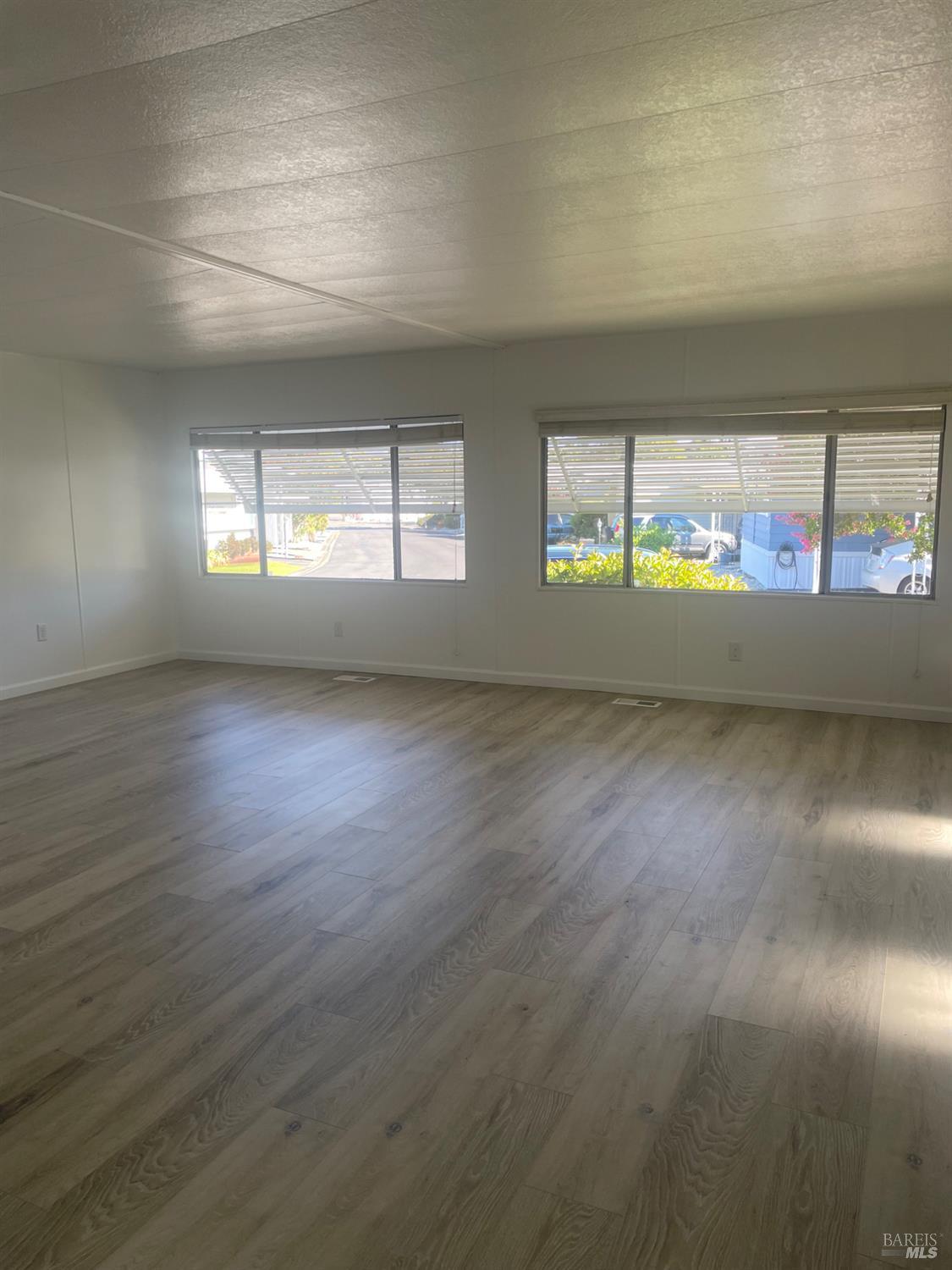 94 Buckwood Place Santa Rosa, CA 95409 - Photo 5 of 25 an empty room with wooden floor and windows