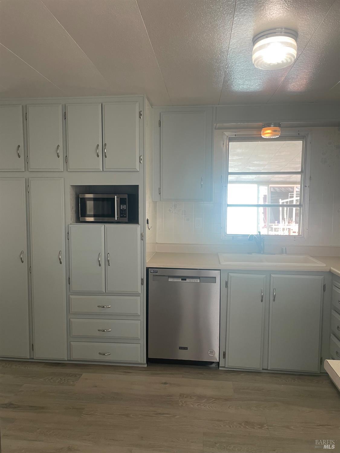 94 Buckwood Place Santa Rosa, CA 95409 - Photo 7 of 25 a kitchen with white cabinets and window