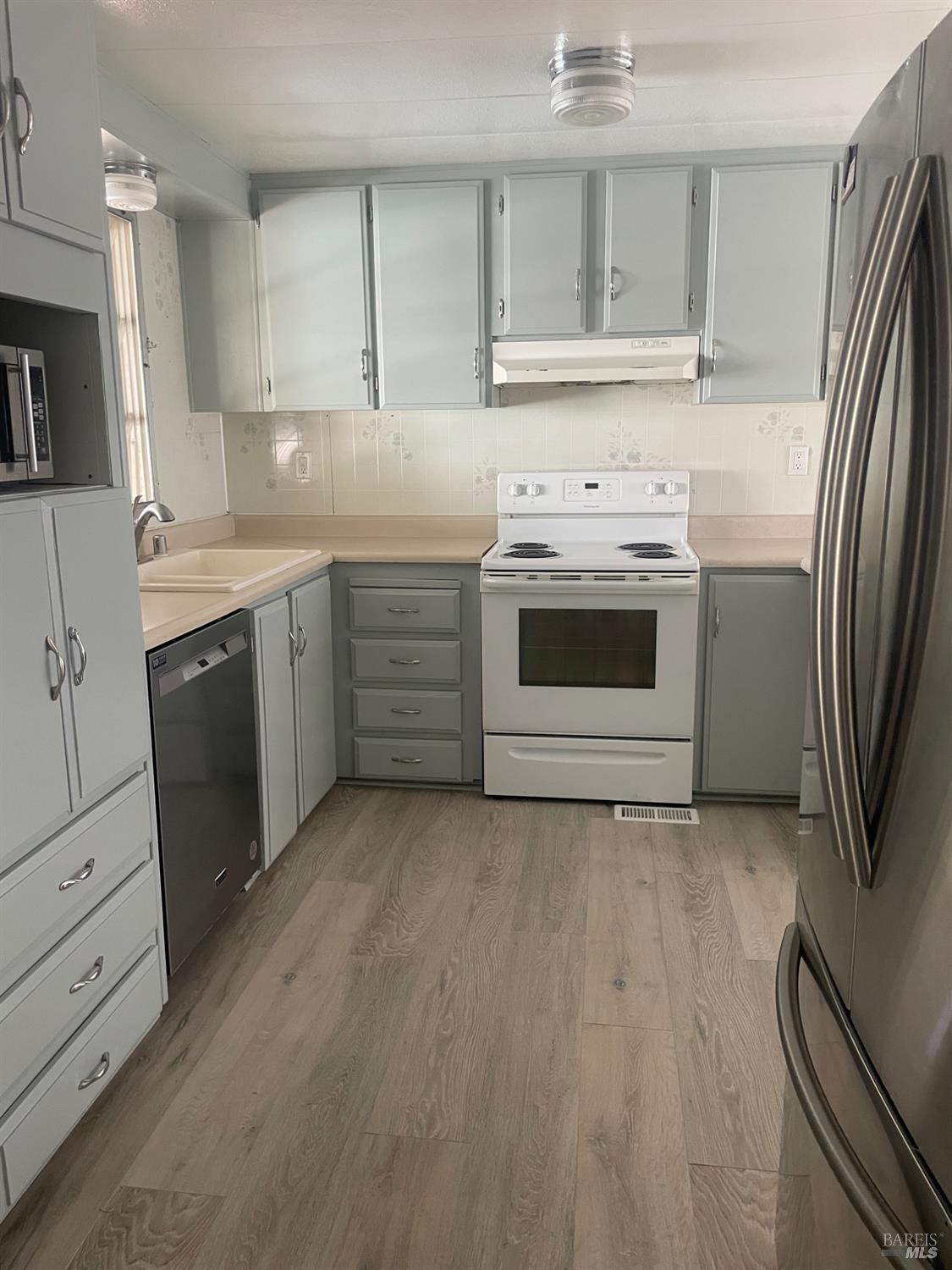 94 Buckwood Place Santa Rosa, CA 95409 - Photo 8 of 25 a kitchen with stainless steel appliances a stove a sink and a refrigerator