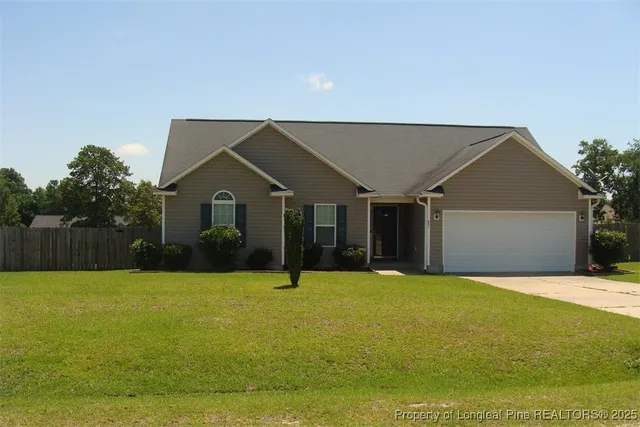 a view of a house with a yard and a garage