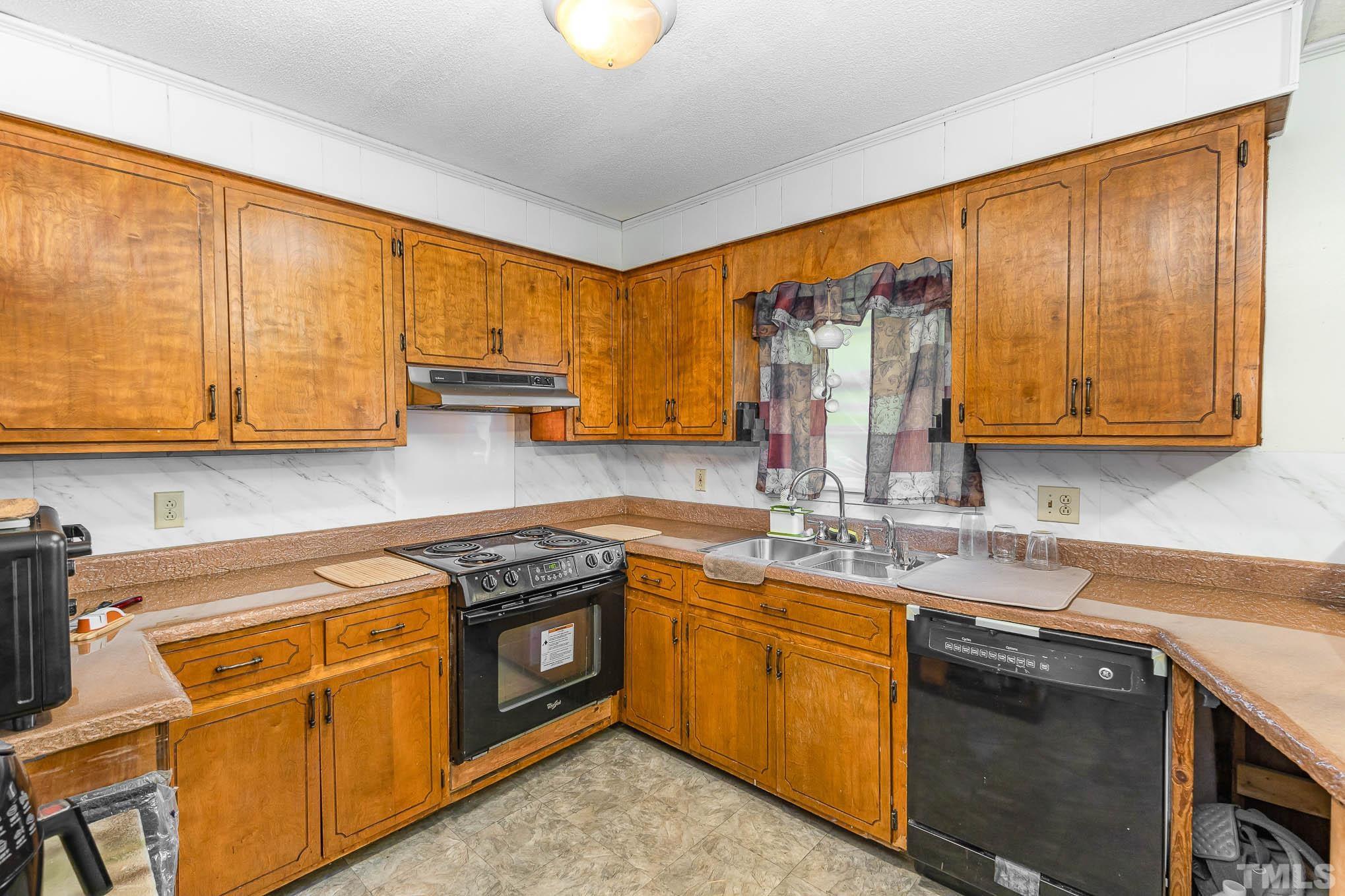 435 Temple Road Bunnlevel, NC 28323 - Photo 11 of 32 a kitchen with stainless steel appliances granite countertop a sink stove and cabinets