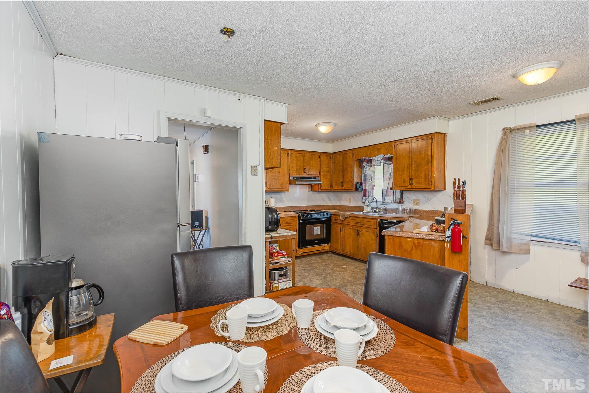 435 Temple Road Bunnlevel, NC 28323 - Photo 10 of 32 a kitchen with stainless steel appliances wooden floor dining table and chairs