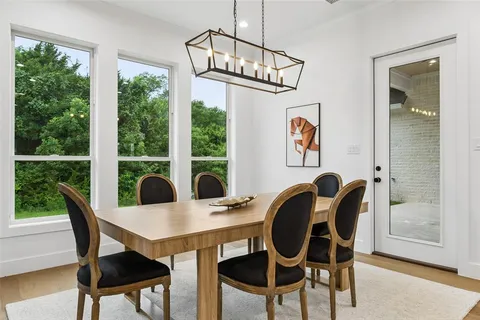 a dining room with furniture a chandelier and wooden floor