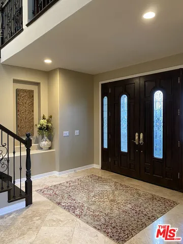 a view of a hallway with wooden floor and a living room