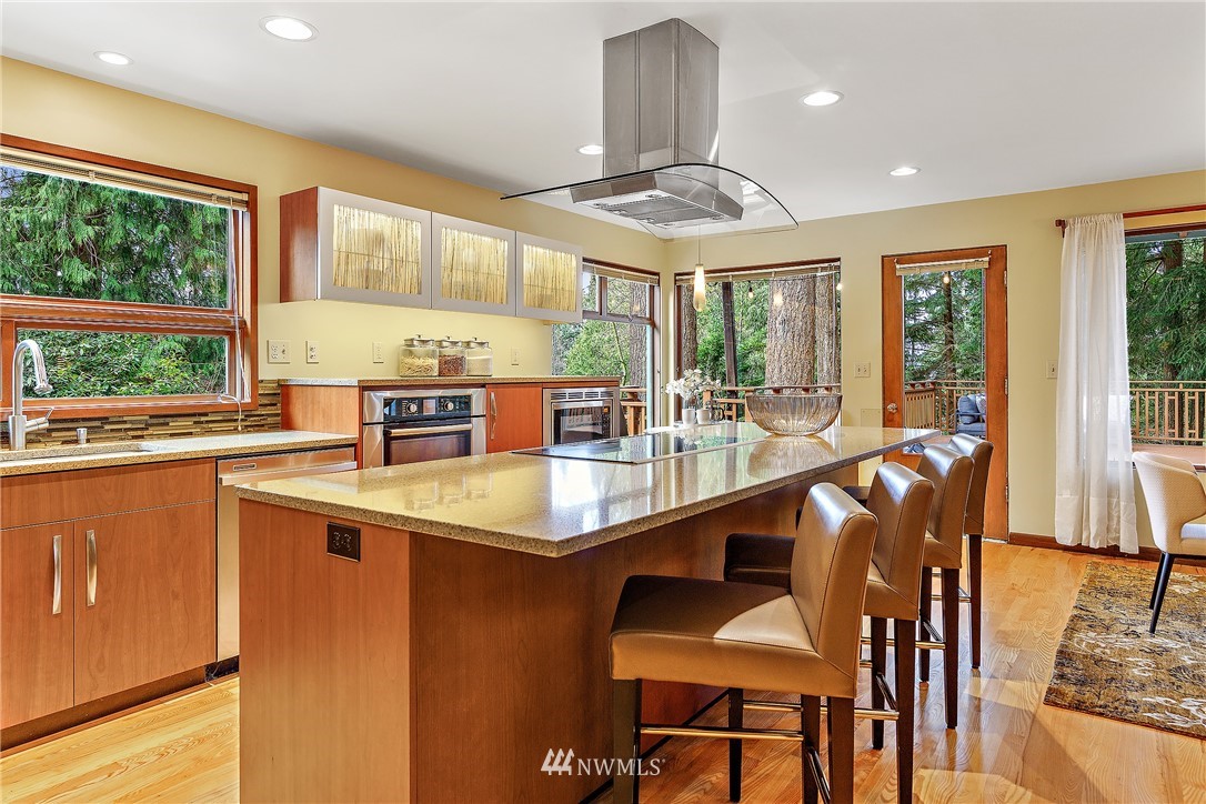 8316 Olympic View Drive Edmonds, WA 98026 - Photo 11 of 38 a dining hall with stainless steel appliances granite countertop a sink a stove a dining table and chairs with wooden floor