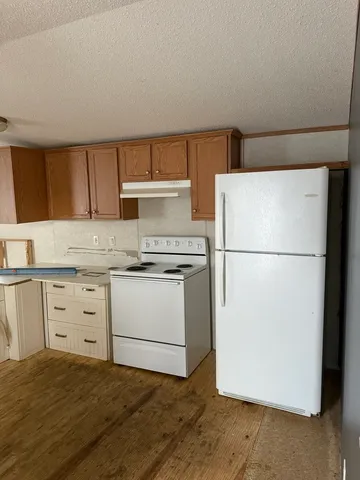 a kitchen with a refrigerator sink stove and cabinets