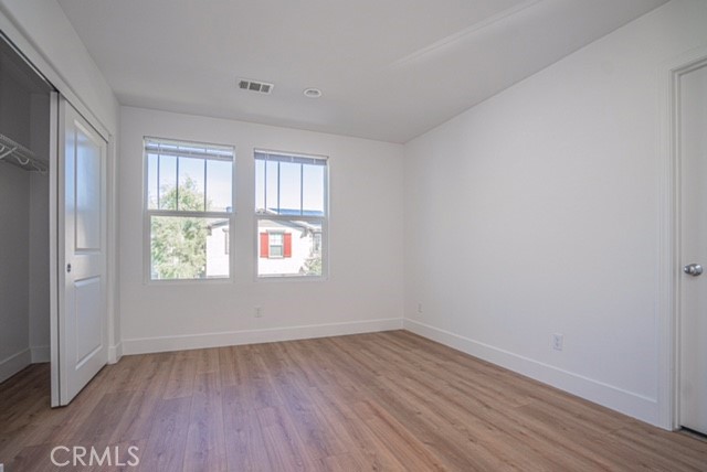 645 Liberation Way Fullerton, CA 92832 - Photo 12 of 20 an empty room with wooden floor and windows