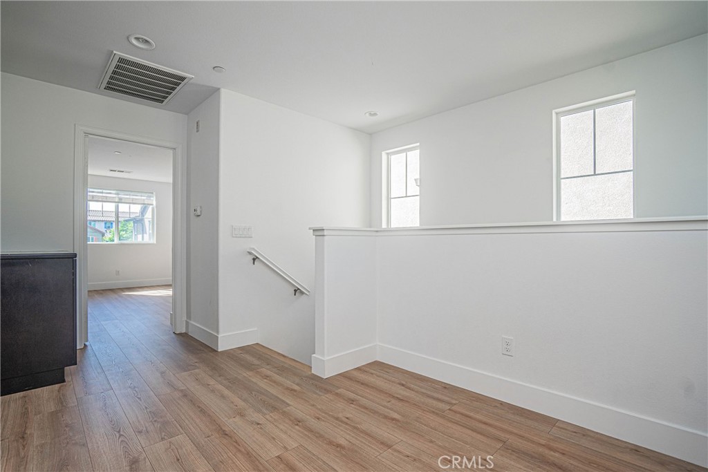 645 Liberation Way Fullerton, CA 92832 - Photo 7 of 20 an empty room with wooden floor and windows