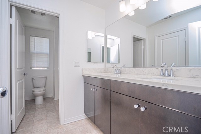 645 Liberation Way Fullerton, CA 92832 - Photo 10 of 20 a bathroom with a sink a toilet and a mirror