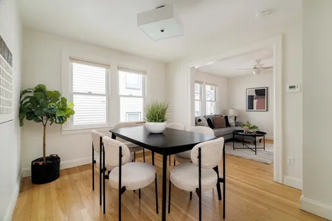 a view of a dining room with furniture and a potted plant