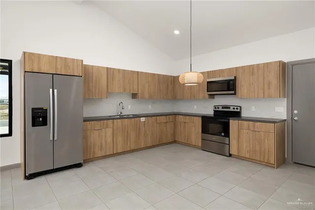 a kitchen with granite countertop a refrigerator and a sink
