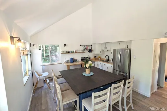 a dining room with stainless steel appliances a table and chairs