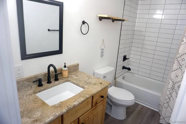 a bathroom with a granite countertop sink toilet and shower