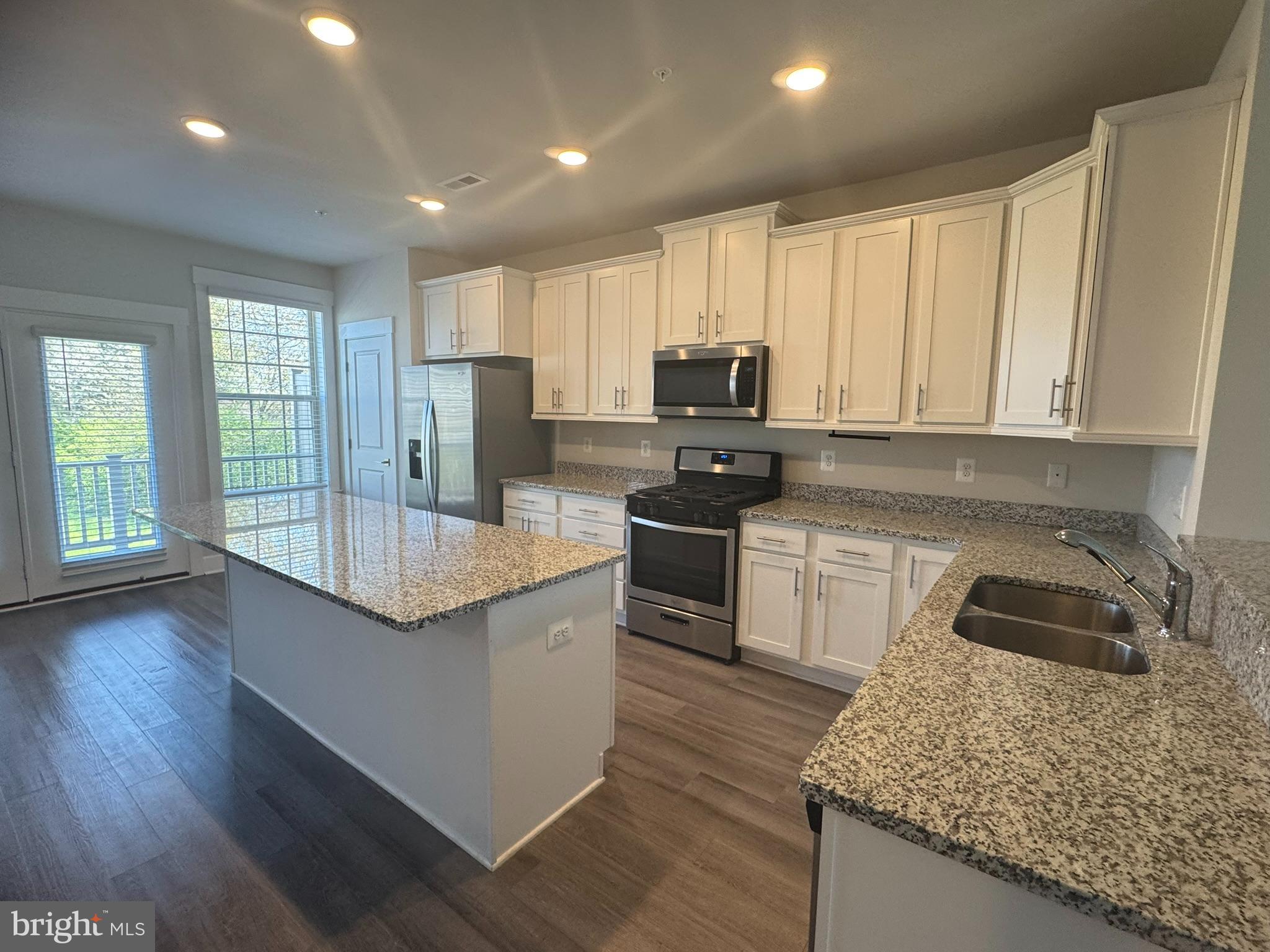 2921 Osprey Way Frederick, MD 21701 - Photo 4 of 27 a kitchen with kitchen island granite countertop a sink a counter top space appliances and cabinets