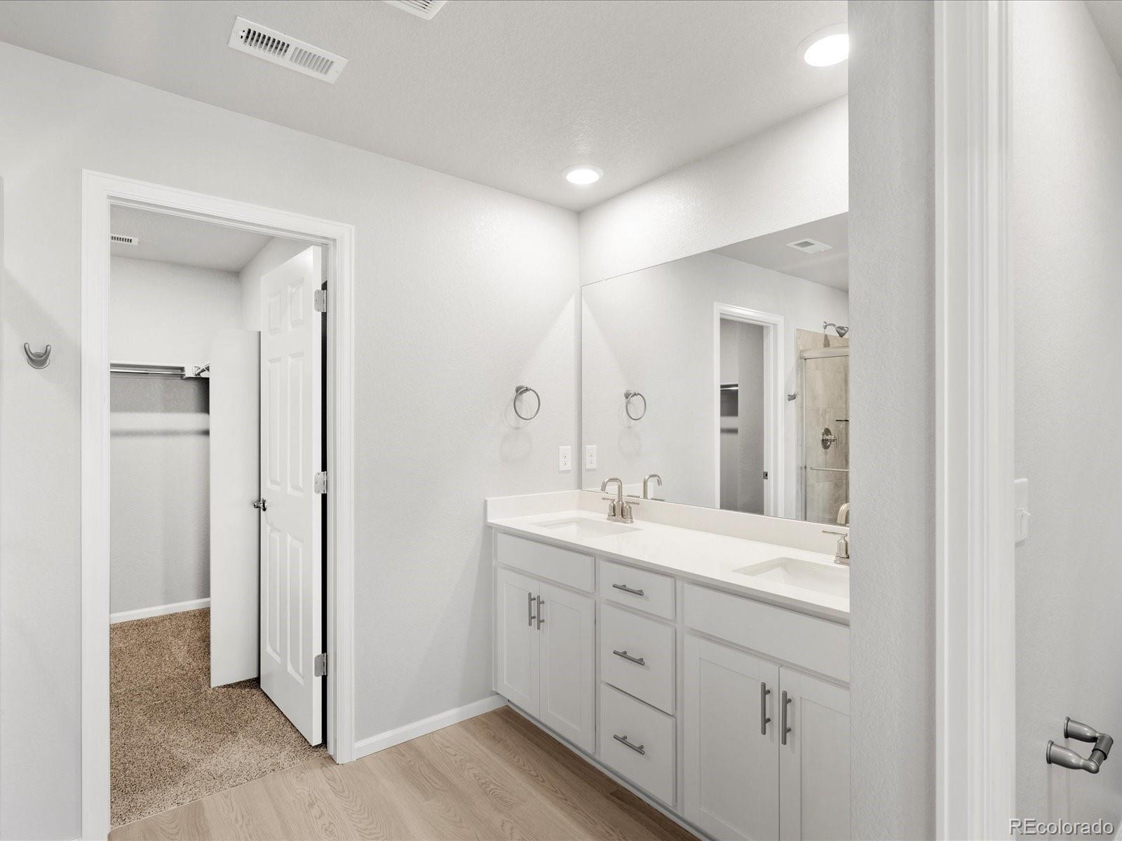 14451 Pansy Loop Morrison, CO 80465 - Photo 21 of 34 a spacious bathroom with a double vanity sink a mirror and a