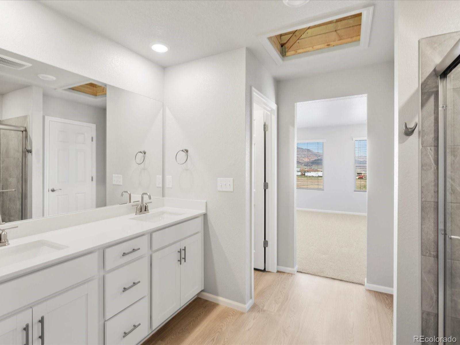 14451 Pansy Loop Morrison, CO 80465 - Photo 23 of 34 a spacious bathroom with a shower a sink and mirror