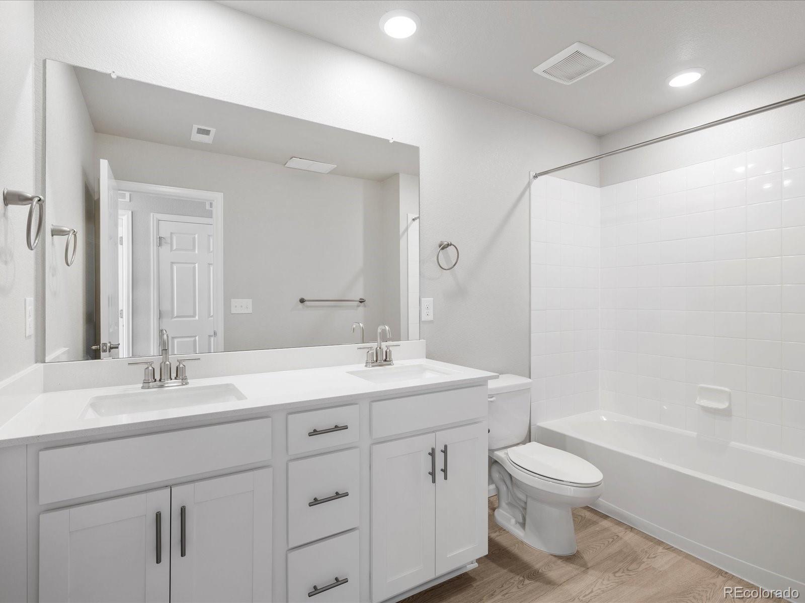14451 Pansy Loop Morrison, CO 80465 - Photo 26 of 34 a bathroom with a double vanity sink toilet mirror and bathtub
