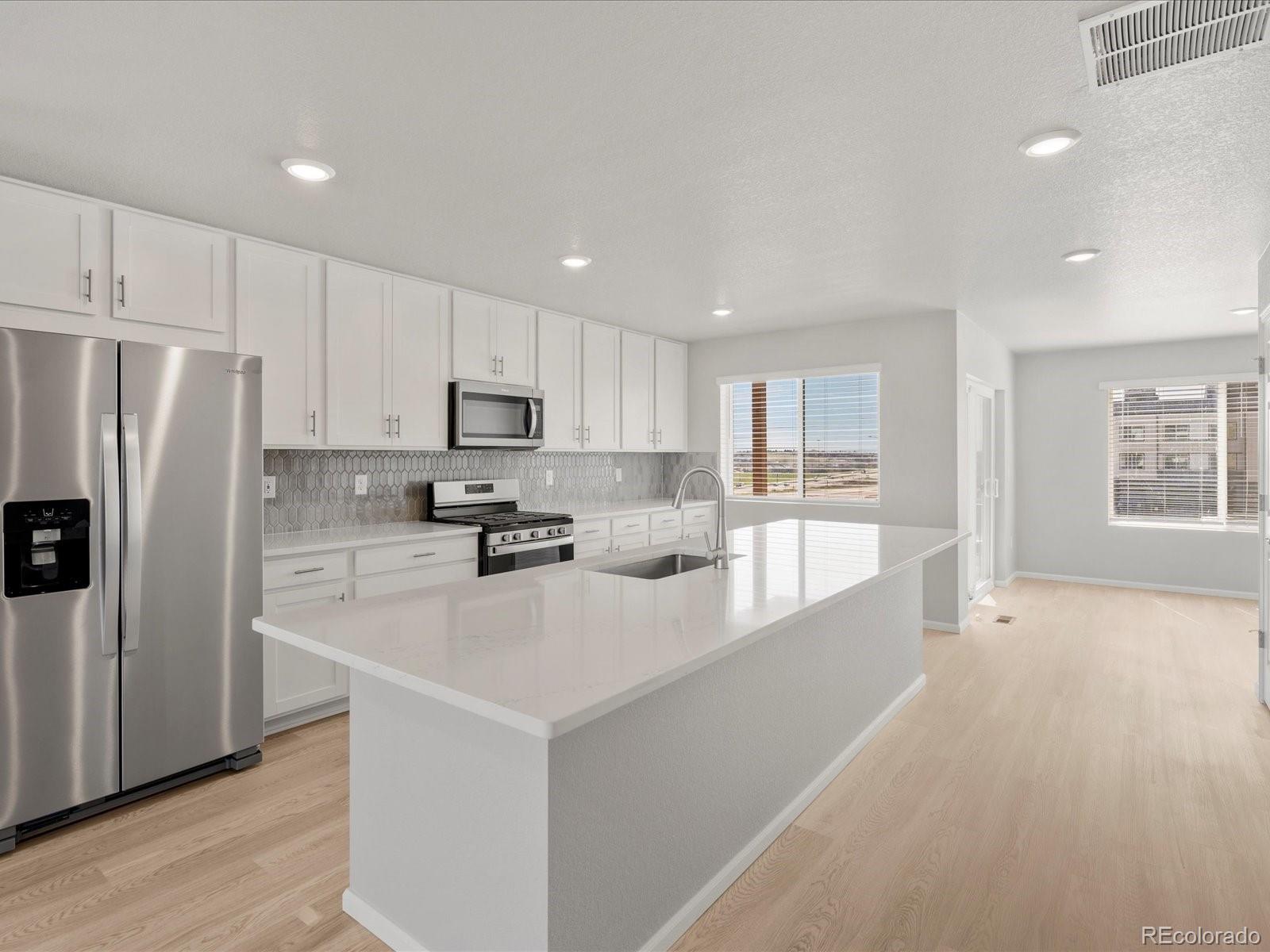 14451 Pansy Loop Morrison, CO 80465 - Photo 5 of 34 a kitchen with a refrigerator a stove top oven a sink and cabinets