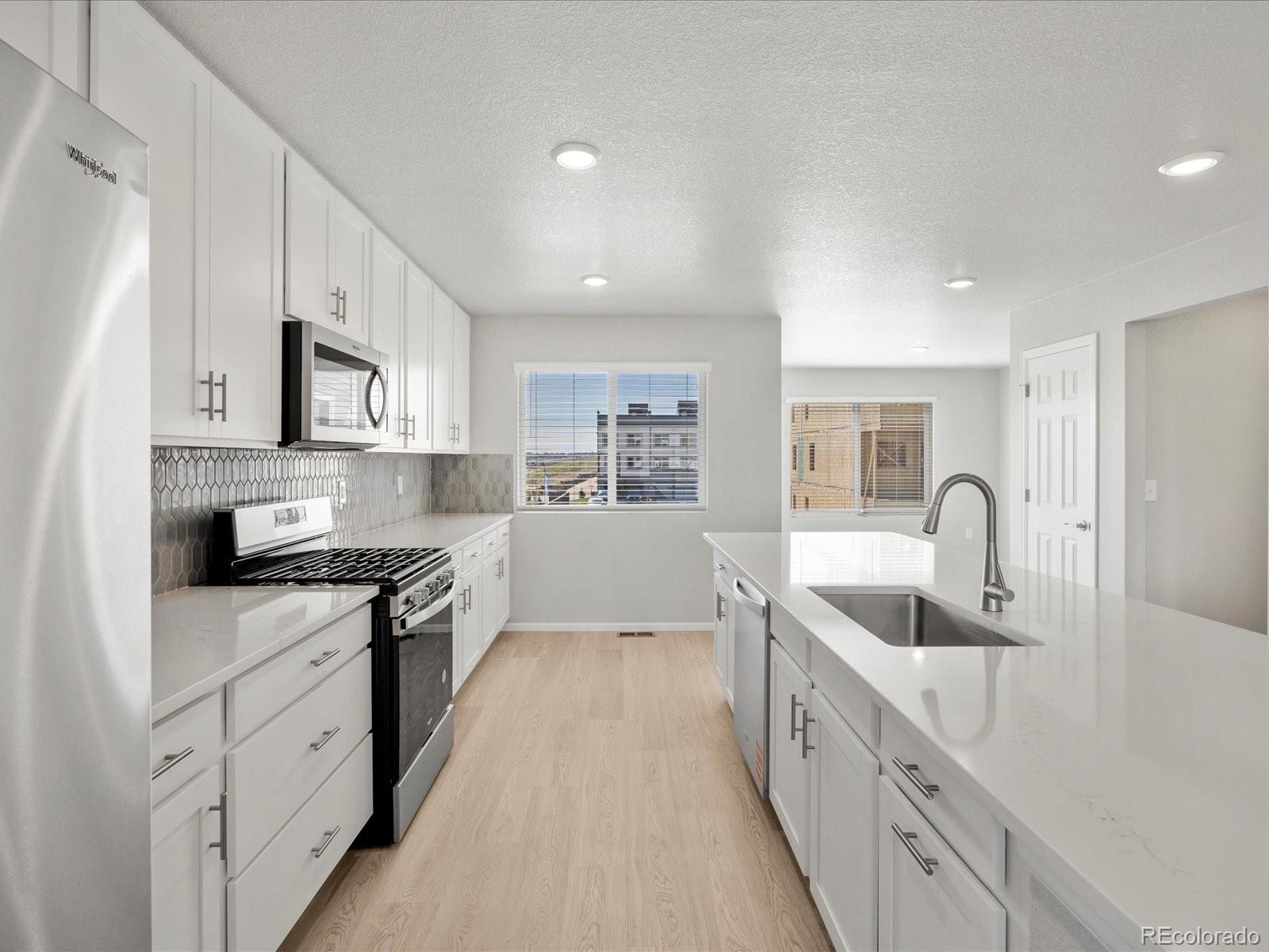 14451 Pansy Loop Morrison, CO 80465 - Photo 6 of 34 a large kitchen with stainless steel appliances granite countertop a lot of counter space and wooden floors