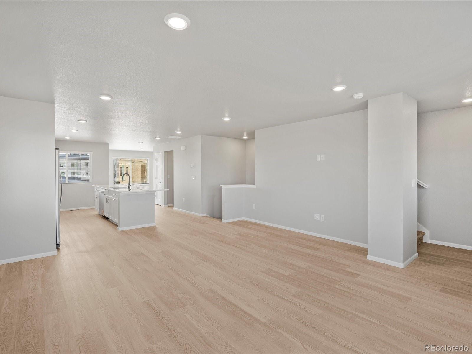 14451 Pansy Loop Morrison, CO 80465 - Photo 10 of 34 a view of an empty room with wooden floor and a kitchen