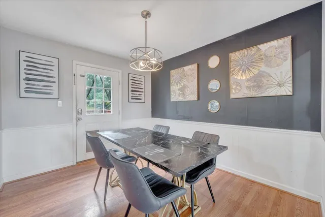 a view of a dining room with furniture wooden floor and a chandelier