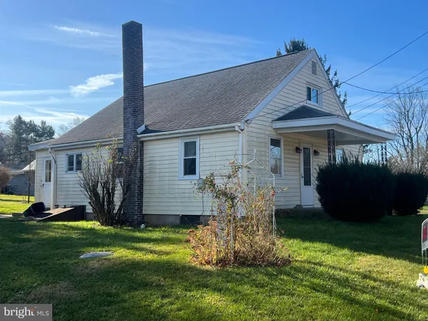 a view of a house with backyard and a tree