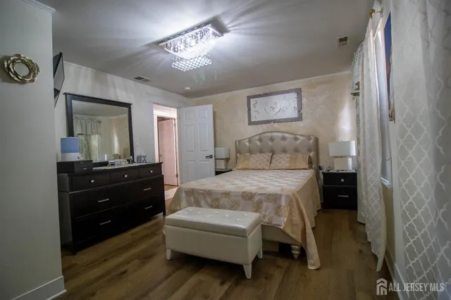 a bedroom with a bed and a mirror on dresser