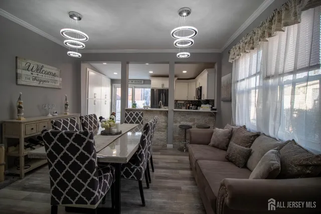 a living room with furniture a chandelier and kitchen view