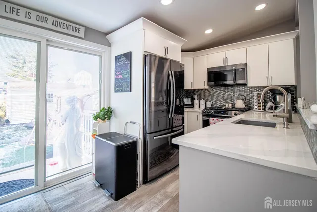 a kitchen with stainless steel appliances a refrigerator sink and stove