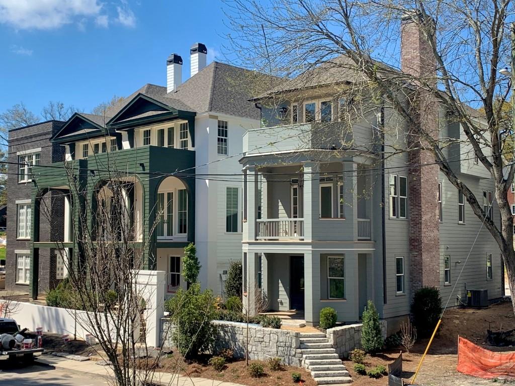 a front view of a building with glass windows and a tree