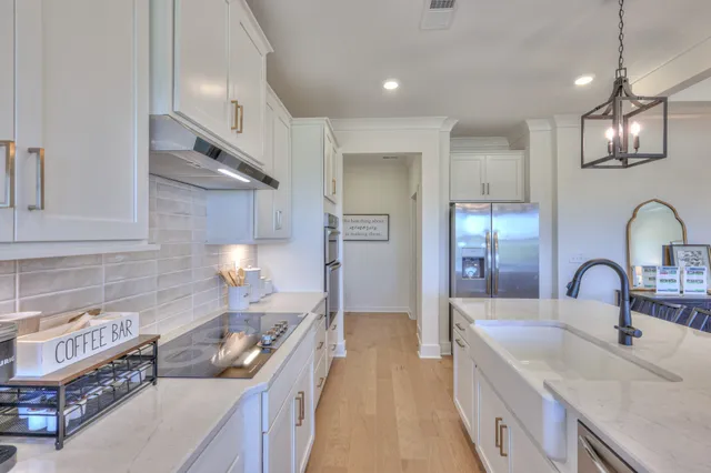 a kitchen with granite countertop a stove and white cabinets