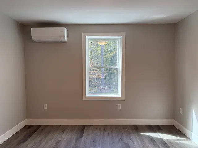 a view of an empty room with wooden floor