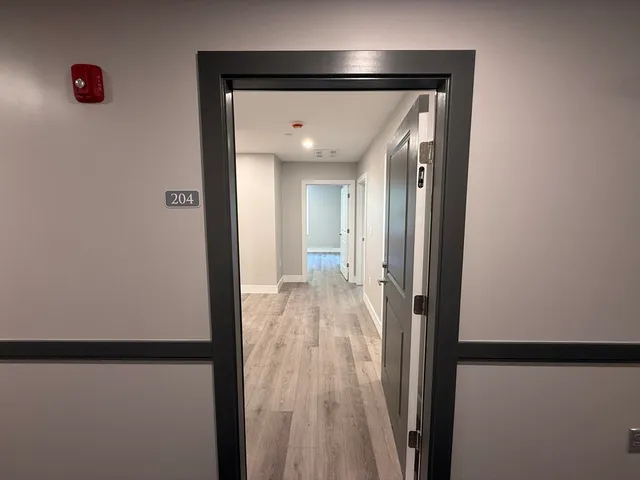 a view of a hallway with wooden floor
