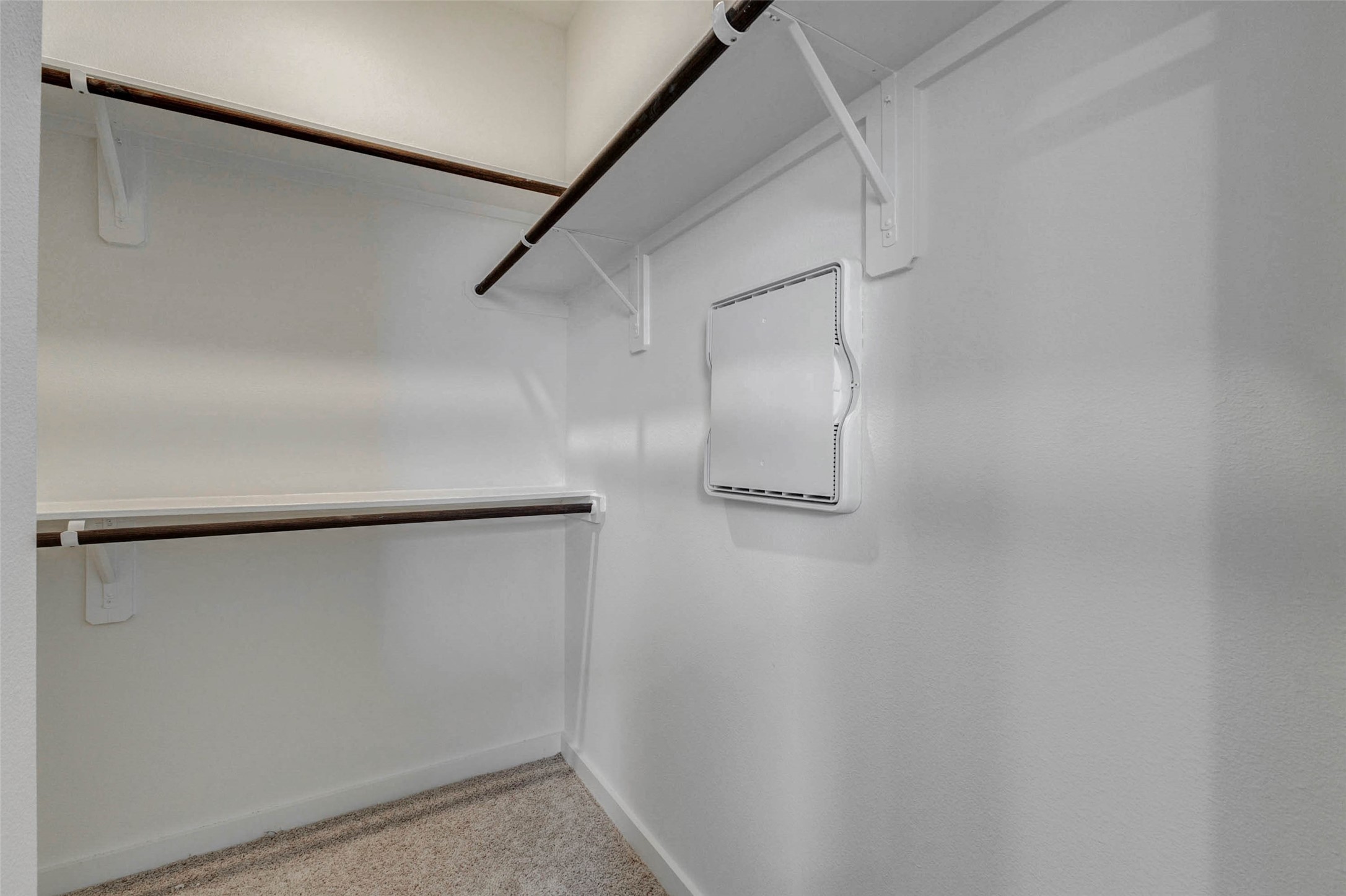 6471 Escondido Drive Rosharon, TX 77583 - Photo 21 of 33 Walk-in closet with built-in shelving and hanging rods, offering practical storage for clothing, shoes, and accessories. The carpeted floor, white walls, and organized layout make this closet a useful extension of the primary suite with room to keep essentials neatly arranged.