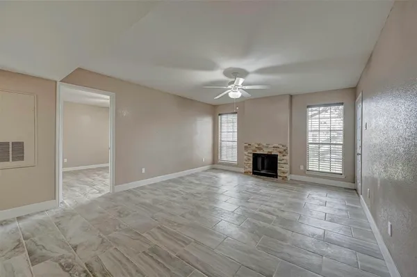 a view of a livingroom with wooden floor fireplace and window