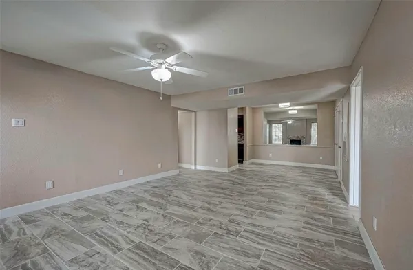 a view of an empty room and kitchen view