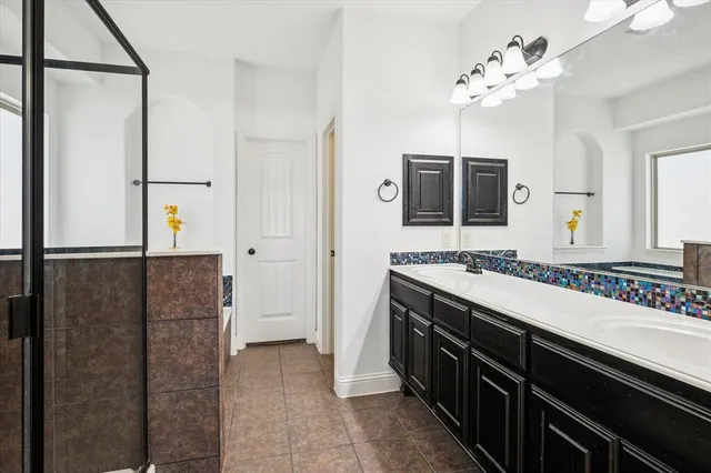 a spacious bathroom with a granite countertop sink a mirror and a shower