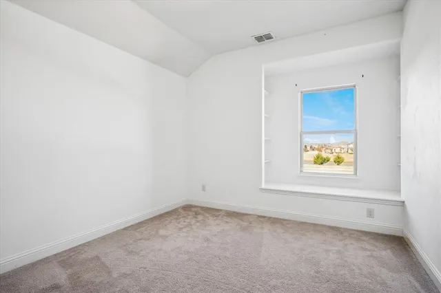 an empty room with a window and a ceiling fan